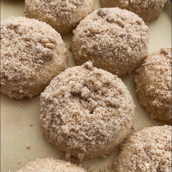Close-up of several vegan PB+J Bar donuts covered in a light brown crumble topping.